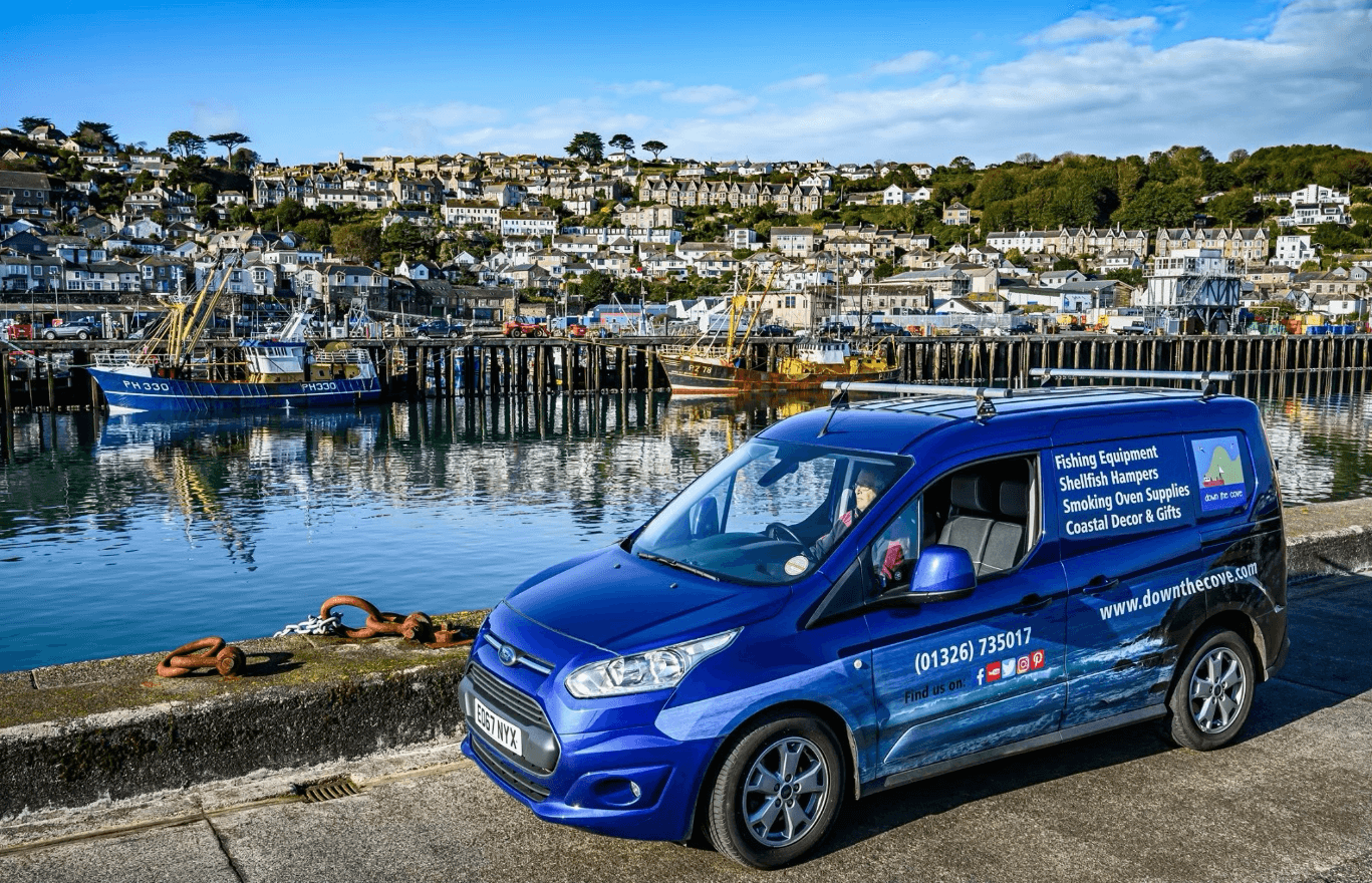 Down The Cove van beside fishing boats in a Cornish harbour