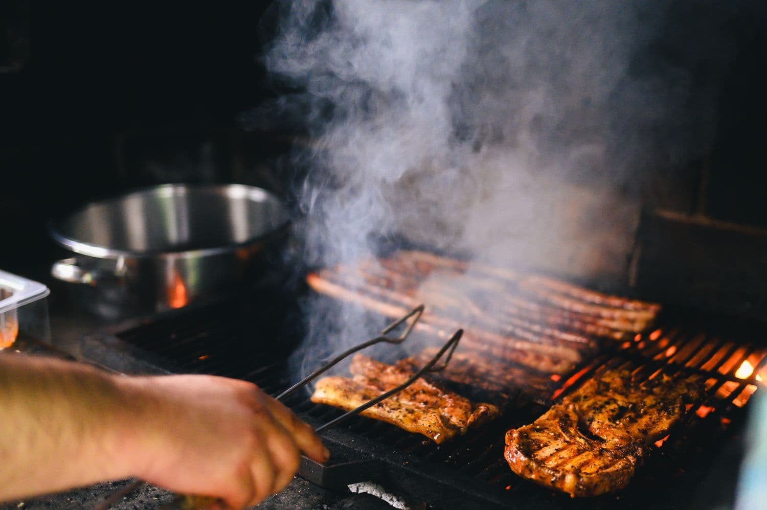 Food smoking over glowing coals with real wood smoke outdoors